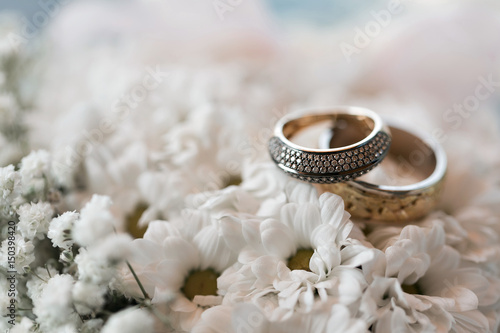 Wedding rings on a white flowers pillow. accessories wedding closeup. selective focus