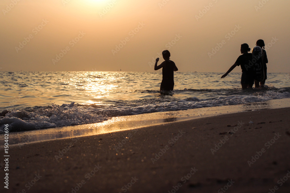 Fototapeta premium Silhouette children playing in the sea.