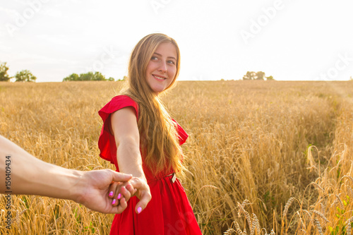 Follow me, Beautiful sexy young woman holds the hand of a man in a wheat field © satura_