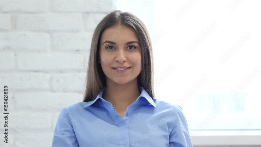 Portrait of Beautiful Smiling Woman Looking at Camera in Office Portrait of Beautiful Smiling Woman Looking at Camera in Office