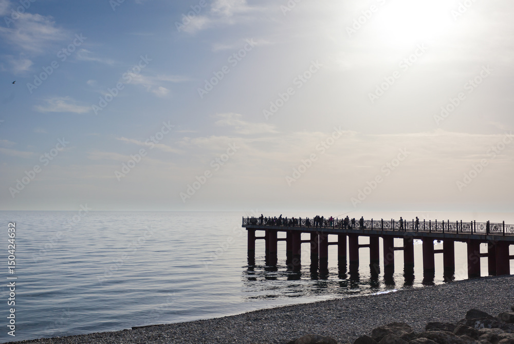 Пирс на берегу моря. Солнце и вода. Берег Черного моря в районе Олимпийского парка в Сочи. Россия.