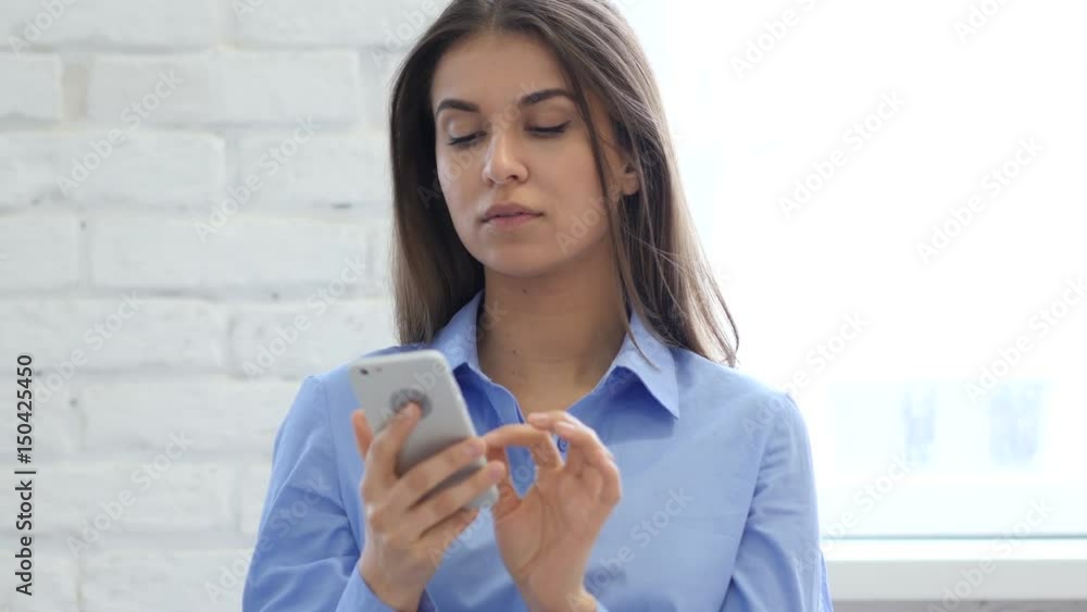 Woman at Work Browsing Smartphone in Office Woman at Work Browsing Smartphone in Office