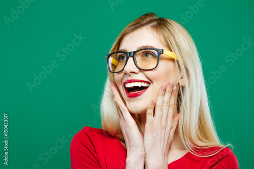 Tableau sur toile Laughing Girl in Eyeglasses and Red Top on Green Background