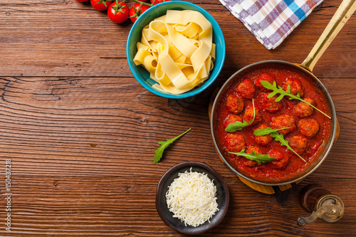 Italian pasta pappardelle with meatballs in tomato sauce.