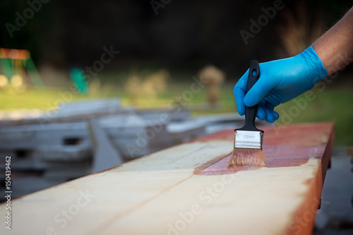 Billede på lærred Hand applying copper based preservative on wood to prevent insect attack and fungal decay