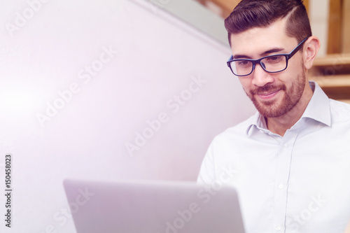 Portrait of young man sitting at the stairs in office