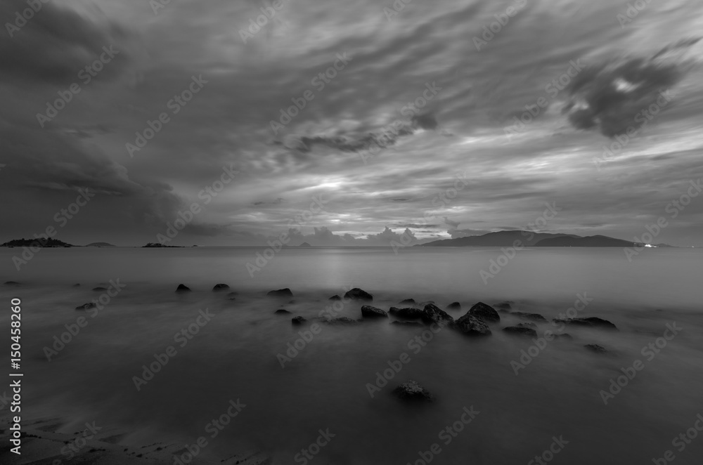 A moody black and white morning sky over Nha Trang bay Vietnam just before sunrise.