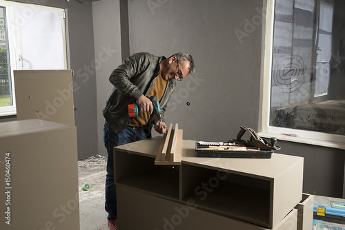 Carpenter Using Cordless Screwdriver 