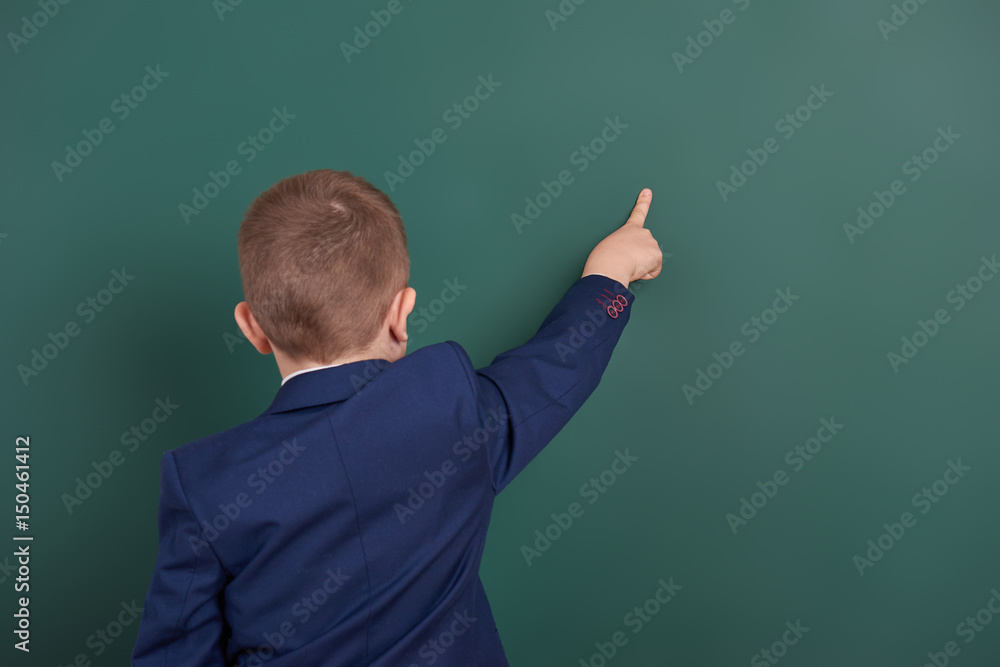 school boy point the finger near blank chalkboard background, dressed in classic black suit, group pupil, education concept school boy point the finger near blank chalkboard background, dressed in classic black suit, group pupil, education concept