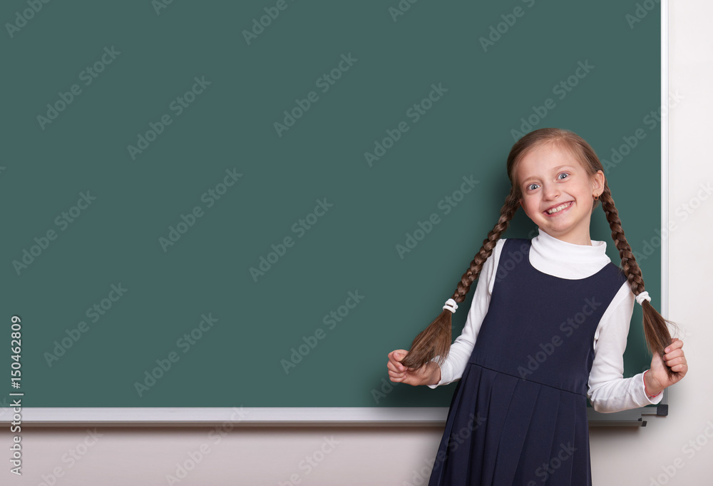 beautiful school girl with pigtail smiled near blank chalkboard background, dressed in classic black suit, education concept beautiful school girl with pigtail smiled near blank chalkboard background, dressed in classic black suit, education concept