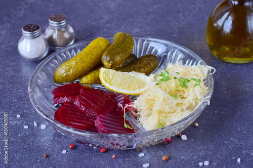 Healthy lunch or dinner with smoked mackerel, pickled cucumbers, beetroot, sauerkraut, french fries on a grey abstract background. Healthy food. Food for fastening photo