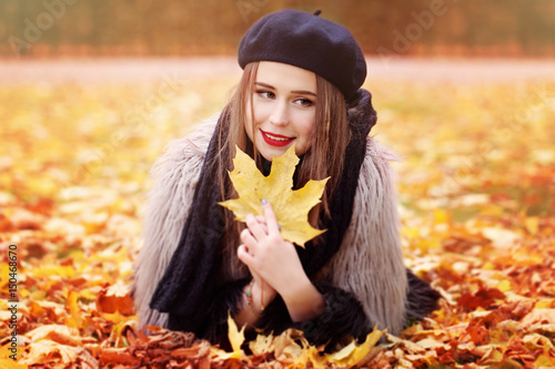 Autumn Woman Lying on Autumn Leaves in the Park Outdoors