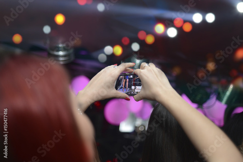 People holding their smartphones and photographing concert