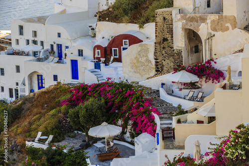 Picturesque view of Old Town of Oia on the island Santorini, white houses, windmills and church with blue domes, Greece