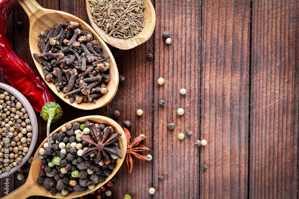 A mixture of spices. Wooden spoon. On Wooden background. Top view. A mixture of spices. Wooden spoon. On Wooden background. Top view.