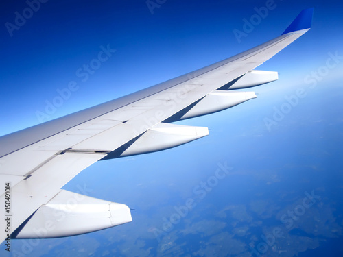 Wing of the plane on blue sky background. Traveling concept. Photo applied to tourism operators