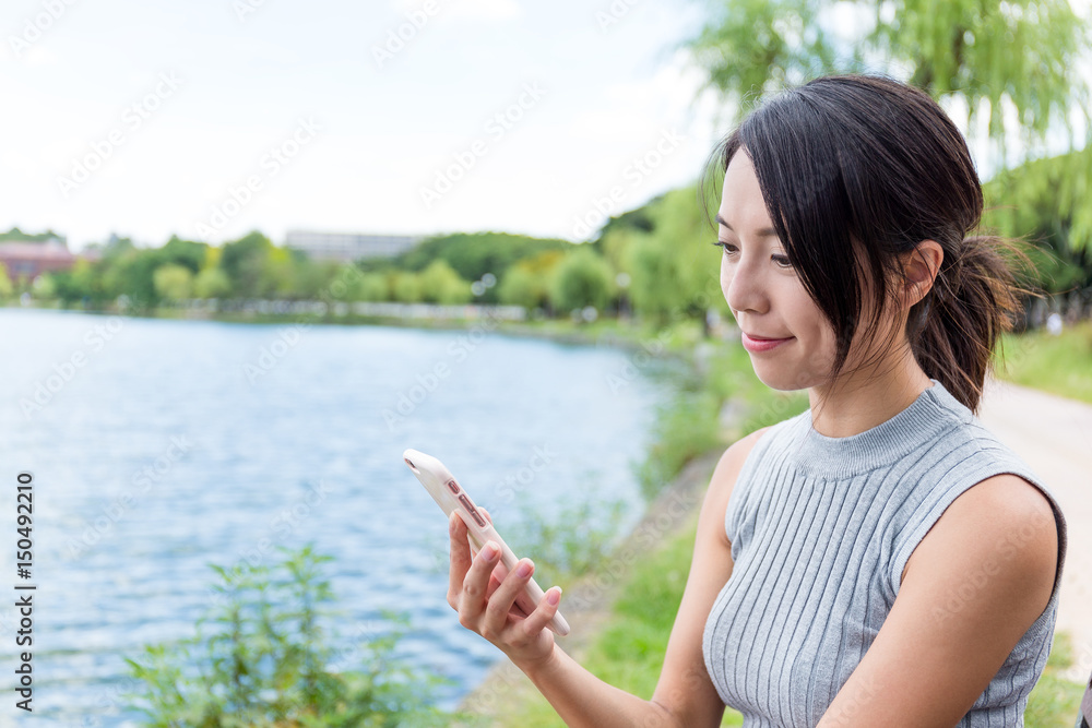 Woma use of mobile phone in park Woma use of mobile phone in park