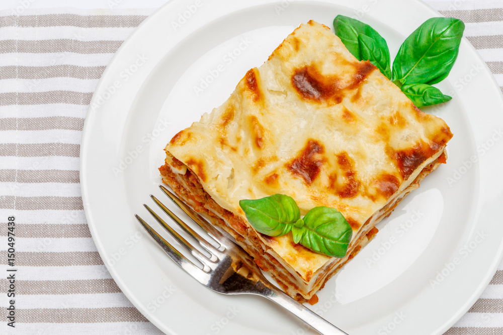 Portion of tasty lasagna isolated on white