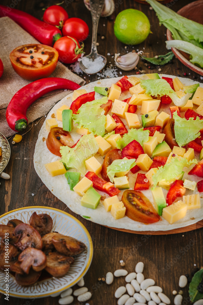 Tortilla with salad over it, surrounded by ingredients. Tortilla with salad over it, surrounded by ingredients.