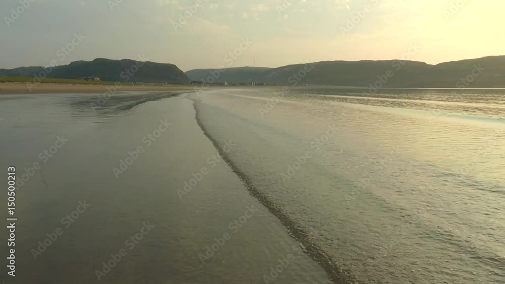 The tide on a sandy beach against the background of low
hills. The waves calmly and rhythmically roll to the shore.
Summer windless evening. The tide on a sandy beach against the background of low
hills. The waves calmly and rhythmically roll to the shore.
Summer windless evening.