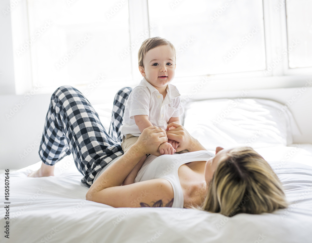 Beautiful young mother and son lying together on a bed Beautiful young mother and son lying together on a bed