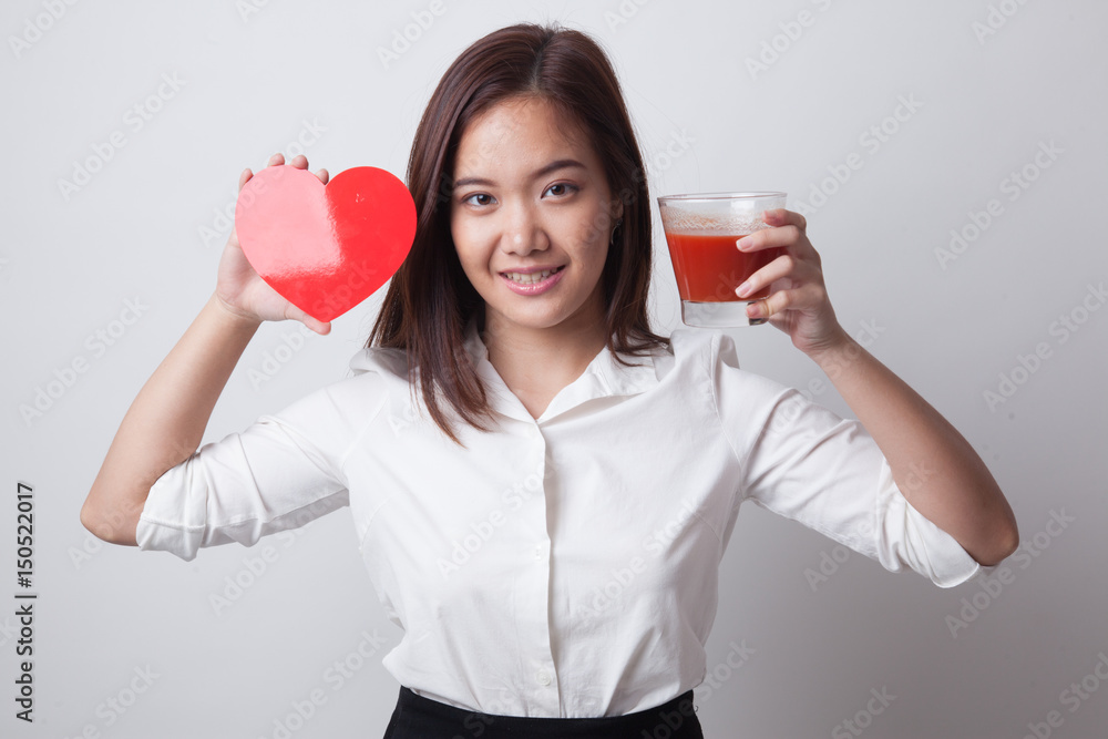 Young Asian woman with tomato juice and red heart. Young Asian woman with tomato juice and red heart.