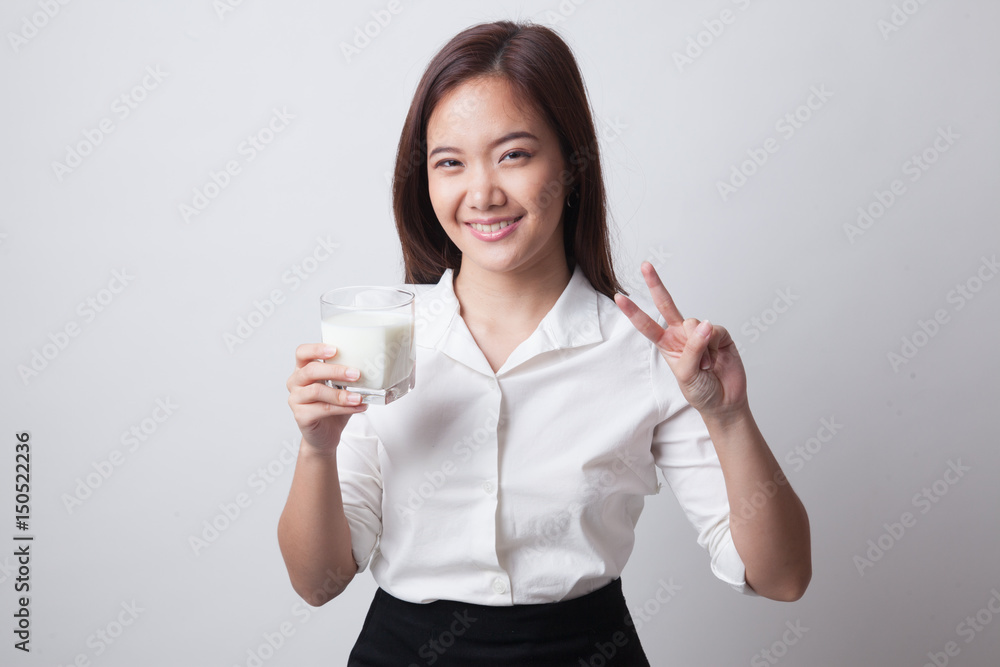 Healthy Asian woman drinking a glass of milk show victory sign. Healthy Asian woman drinking a glass of milk show victory sign.