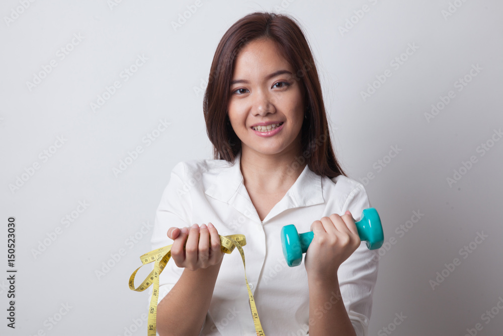 Healthy Asian woman with dumbbells and measuring tape. Healthy Asian woman with dumbbells and measuring tape.