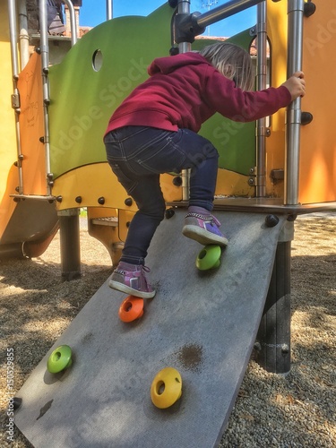 bambina impegnata nella scalata del percorso photo