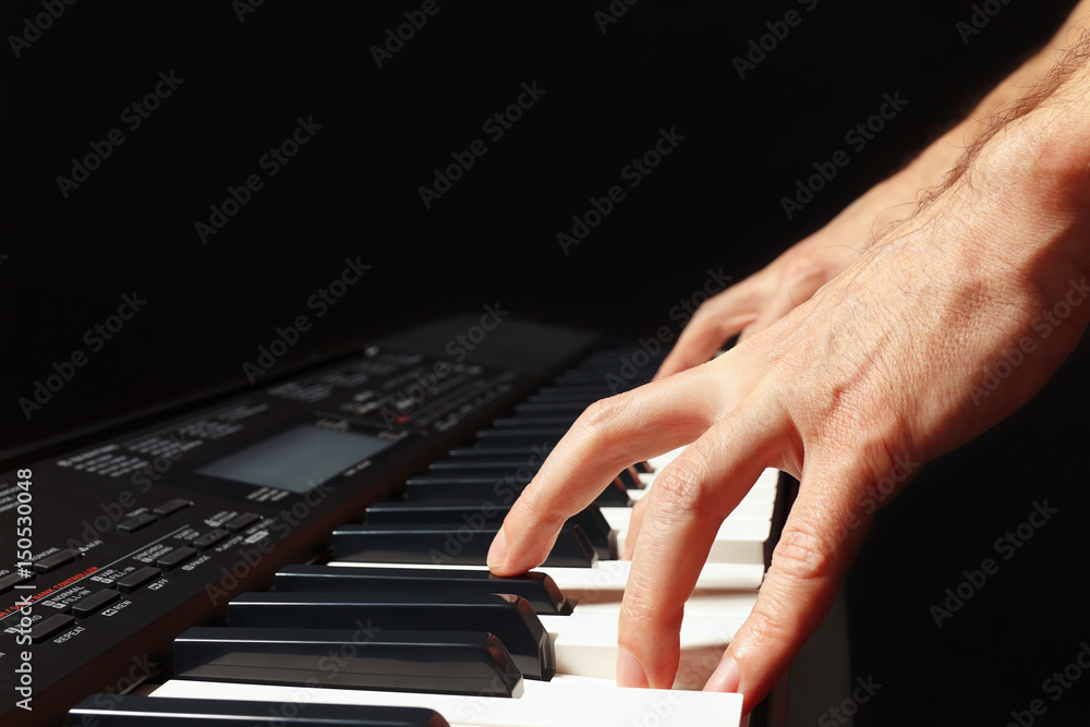 Hands of musician playing the electronic synth on a black background Hands of musician playing the electronic synth on a black background