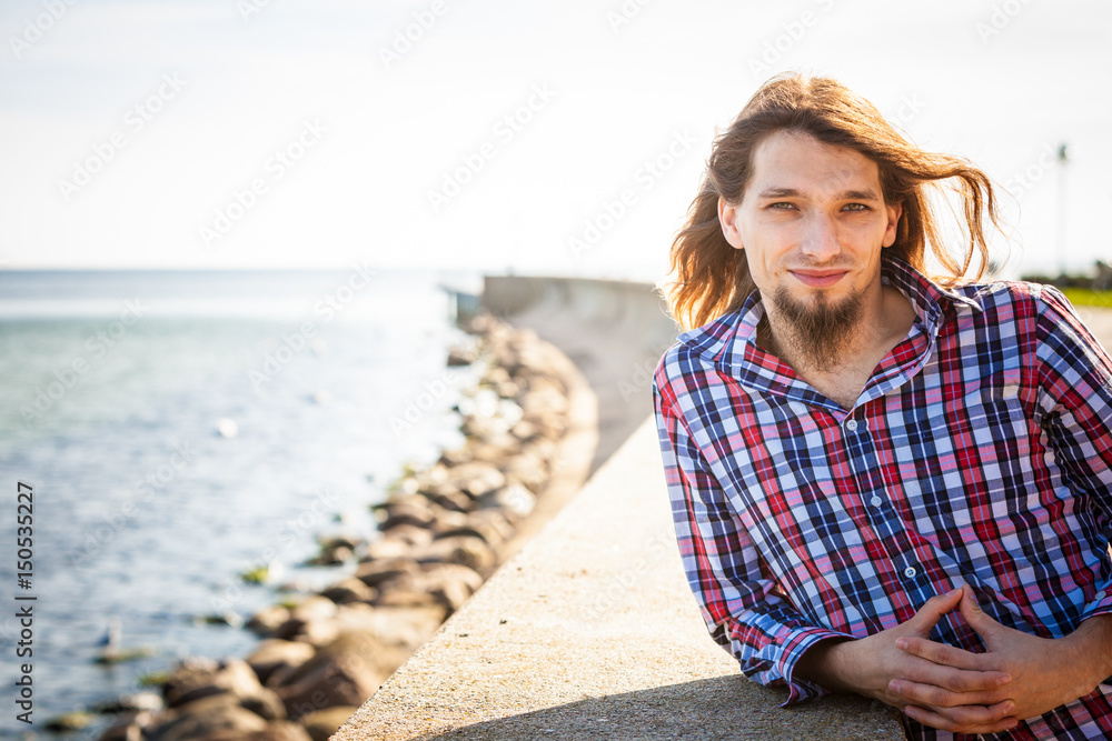 Man long hair relaxing by seaside Man long hair relaxing by seaside
