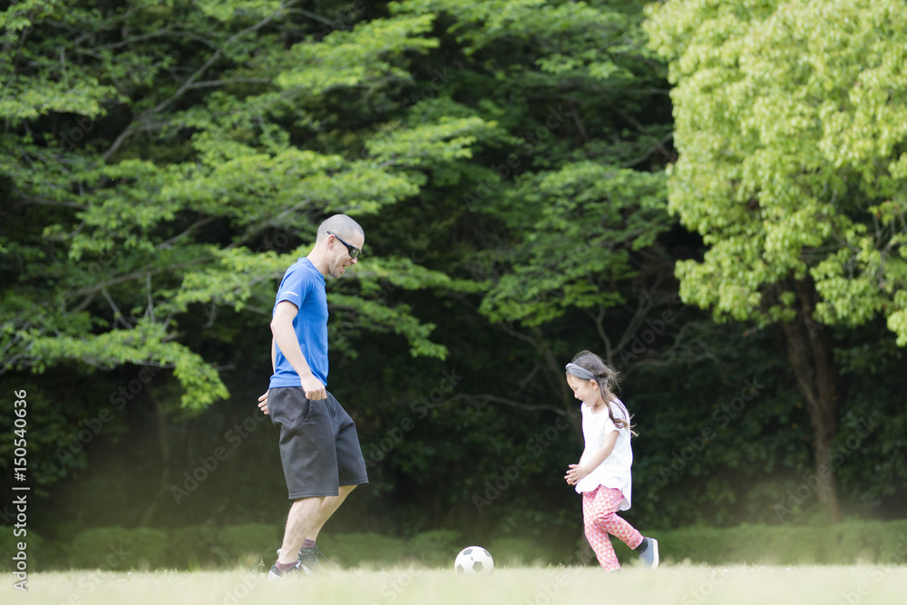 サッカーボールで遊ぶ親子