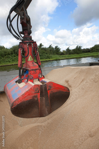 Unloading ship with grain. Barge in canal. Inland transport. Netherlands. photo