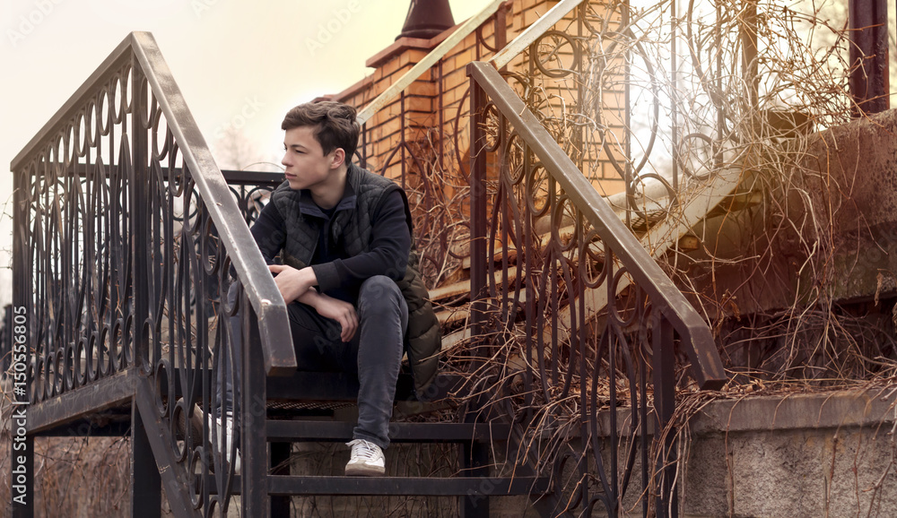 sad young man sitting on the steps sad young man sitting on the steps