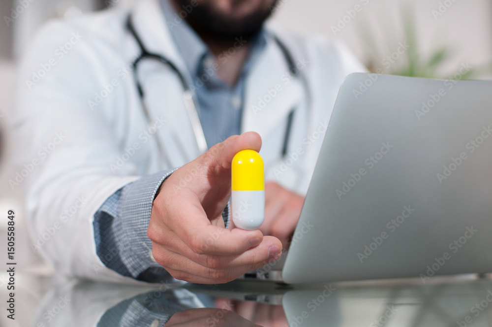 Doctor working on desk with laptop computer