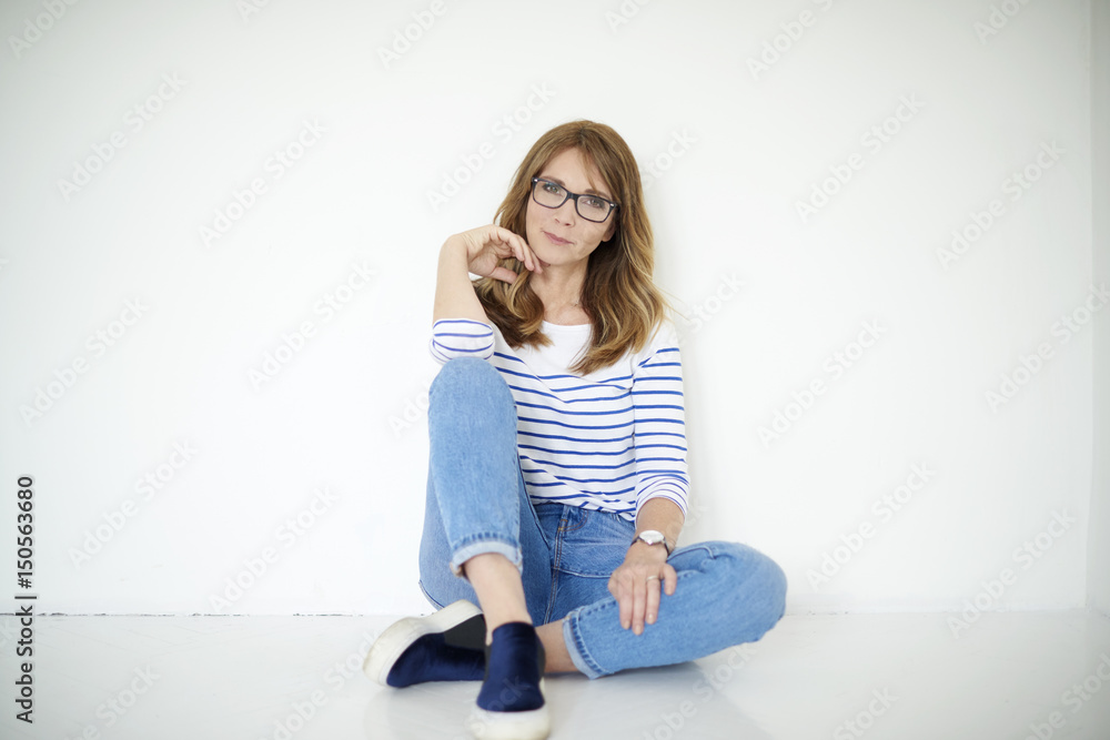 Confident woman portrait. Portrait of a smiling mature woman against white wall with copy space. Confident woman portrait. Portrait of a smiling mature woman against white wall with copy space.