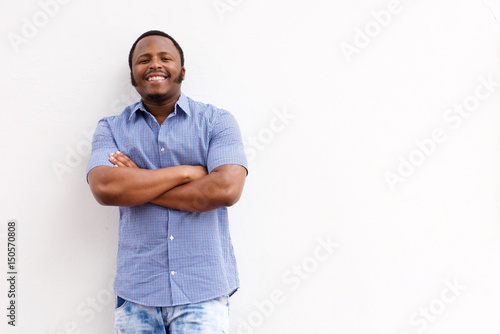 happy young black guy smiling against white wall