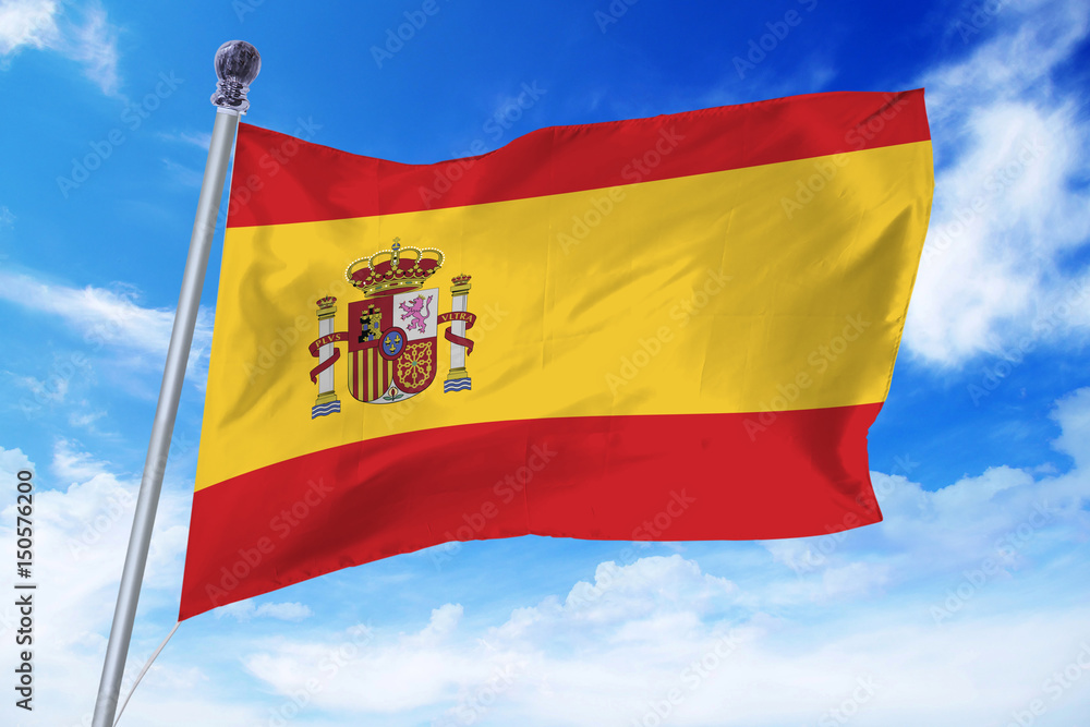 Flag of Spain developing against a clear blue sky Flag of Spain developing against a clear blue sky