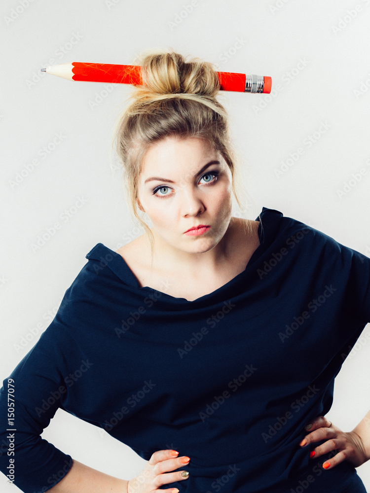 Bored blonde woman having big pencil in hair Bored blonde woman having big pencil in hair