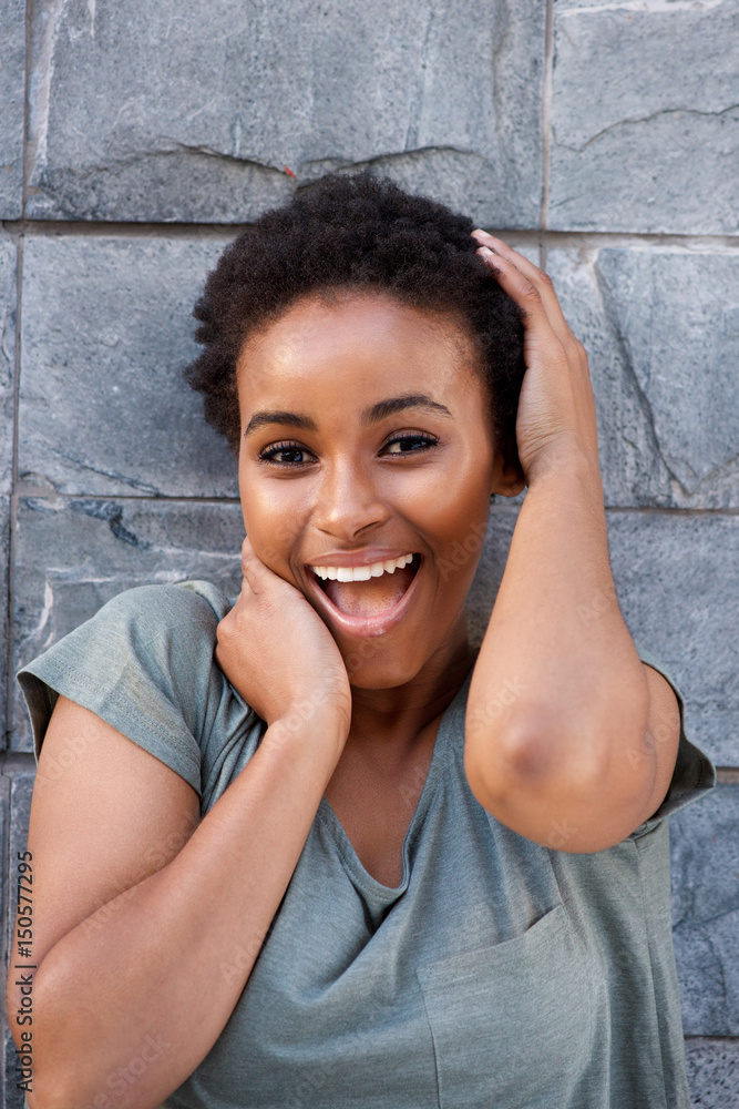 Fototapeta premium beautiful young black woman laughing with hands to face