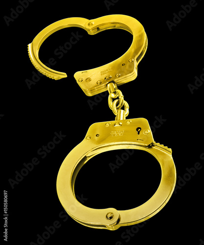 Golden handcuffs - isolated against a black background.