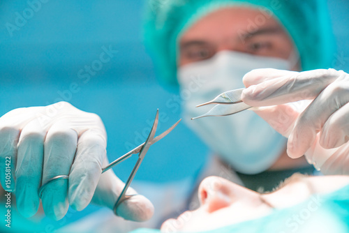 surgeons in operating room take with art lighting and green filter.