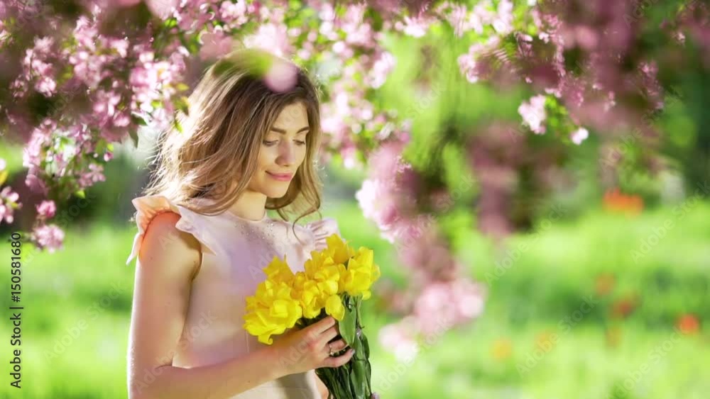 Pretty woman with bouquet of tulips at flowered garden Pretty woman with bouquet of tulips at flowered garden