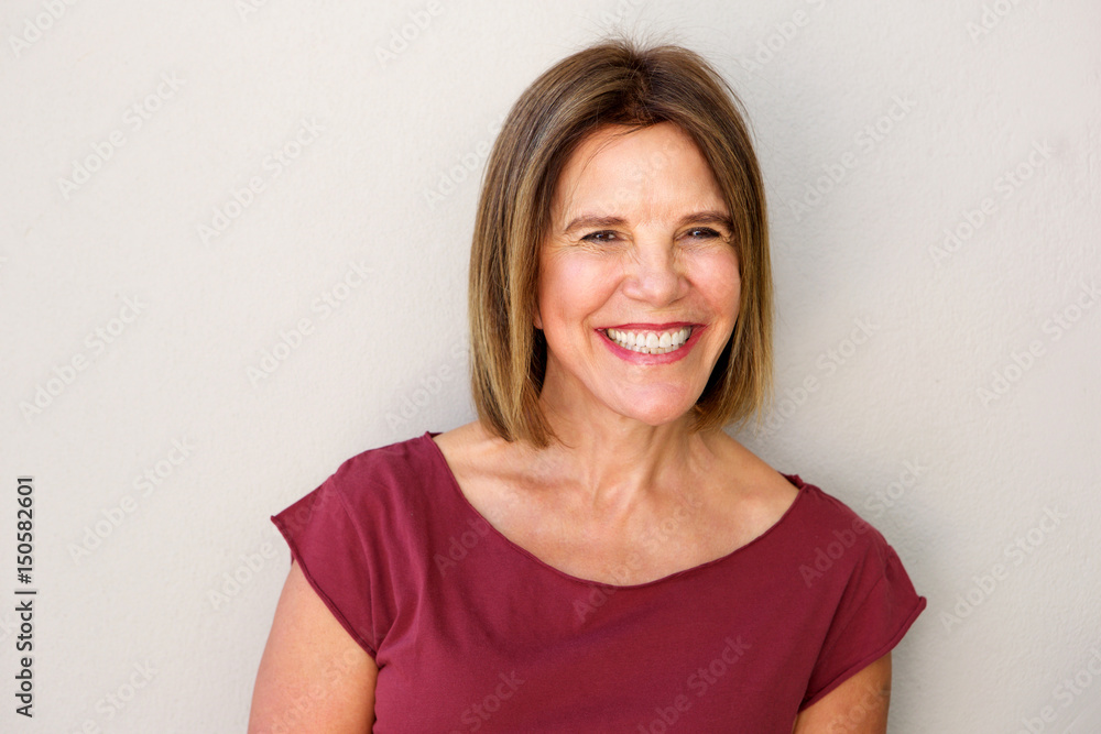 Close up beautiful middle age woman smiling against white wall Close up beautiful middle age woman smiling against white wall