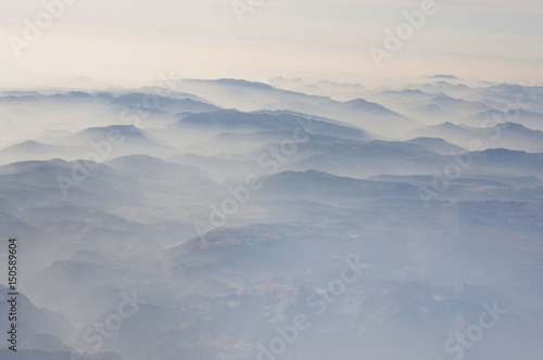 Mountain shop from the plane in Alps at sunset, cloudy, misty mountains © kristinabonphoto
