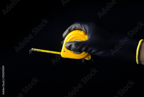hand hold measuring tape on black back ground