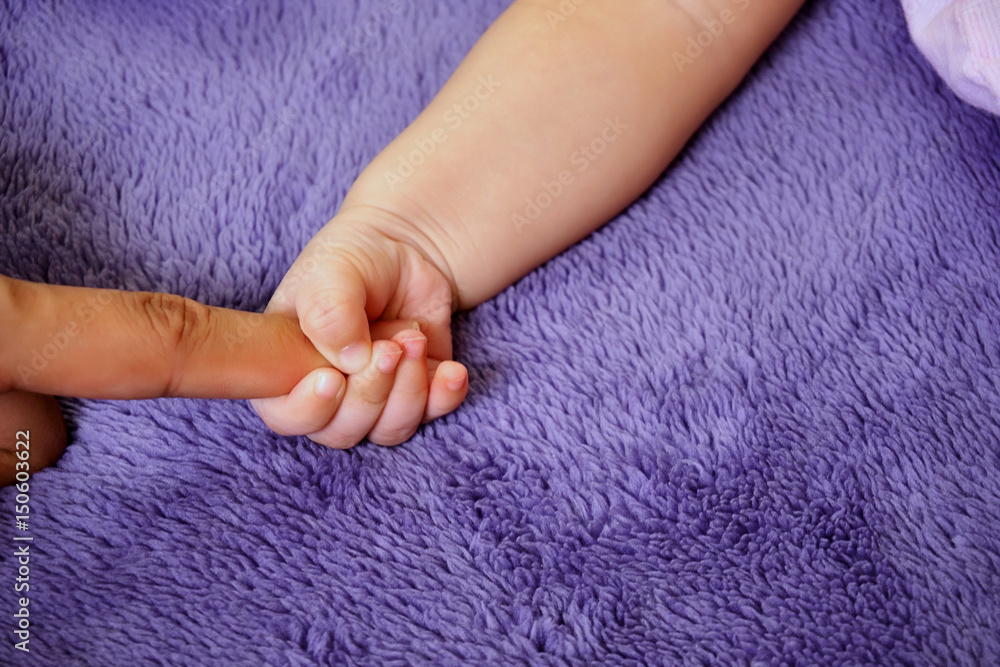 Hand baby holding hand of mother's closeup. concept love of family. Hand baby holding hand of mother's closeup. concept love of family.