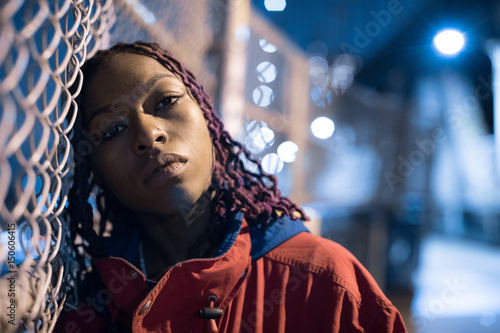 Urban portrait of a young, black woman in the streets of New York City. The model poses on the city's Manhattan Bridge.