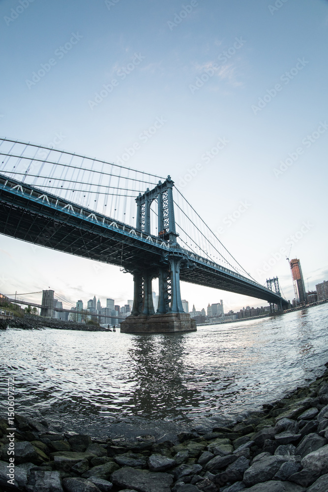 Naklejka premium Kultowe ujęcie mostu Manhattan Bridge w Nowym Jorku - DUMBO, Brooklyn. Kręcone z bruku Washington Street wiosną 2017 roku obiektywem typu rybie oko.