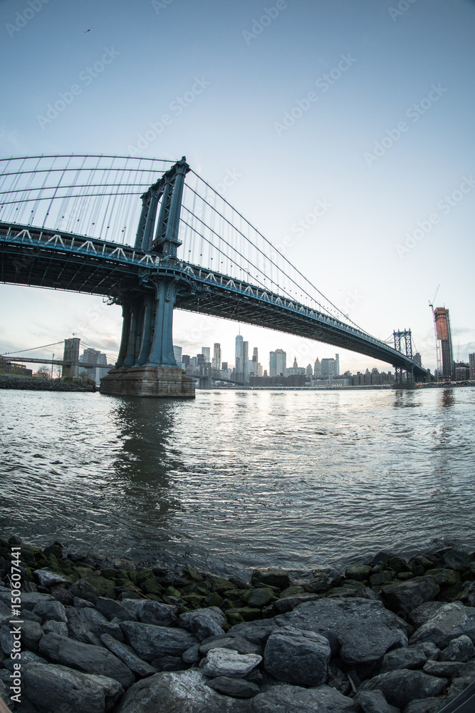 Fototapeta premium An iconic shot of New York City's Manhattan Bridge - DUMBO, Brooklyn. Shot from the Cobblestone of Washington Street during the Spring of 2017 with a Fisheye Lens.